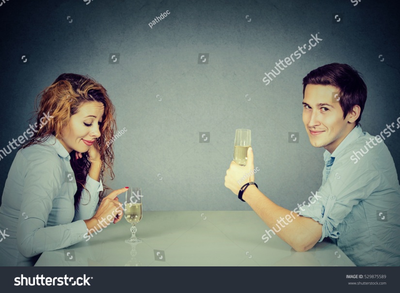 stock-photo-sly-man-and-skeptical-woman-sitting-at-table-drinking-wine-529875589